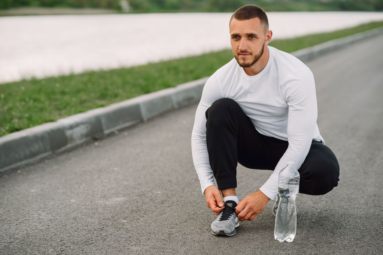 A man tying his sports shoes outdoors before exercise